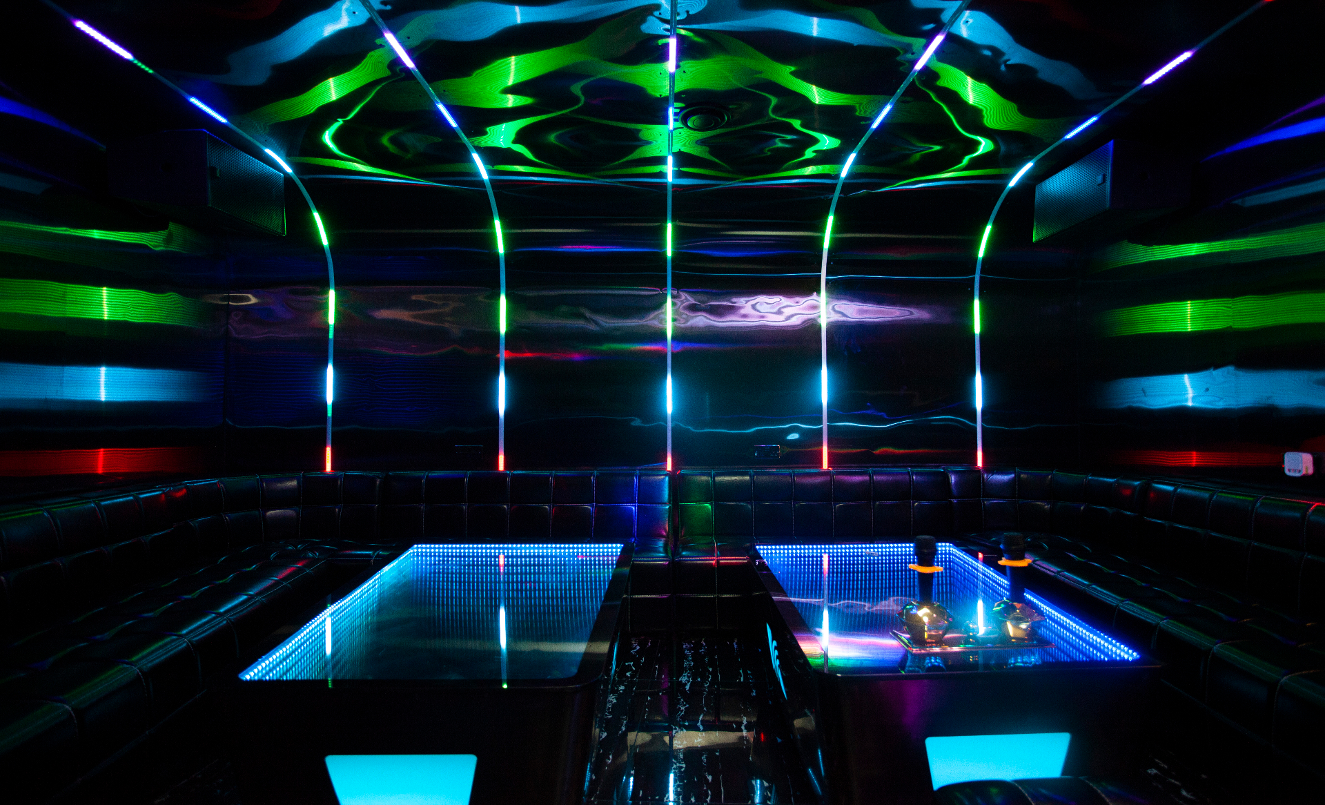 Private karaoke room K3 with electric blue neon lighting and leather banquettes