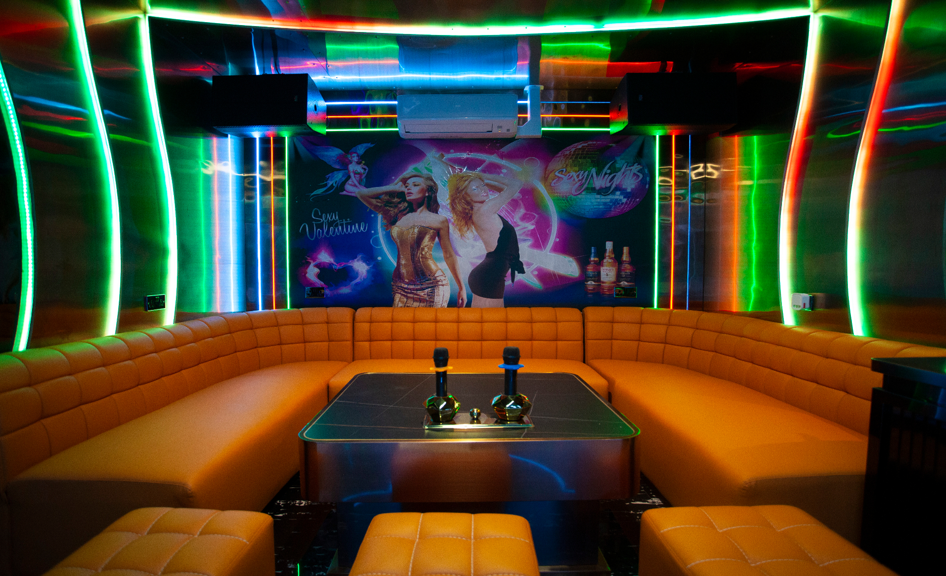 Private karaoke room K5 with pink and blue neon washes and a big screen