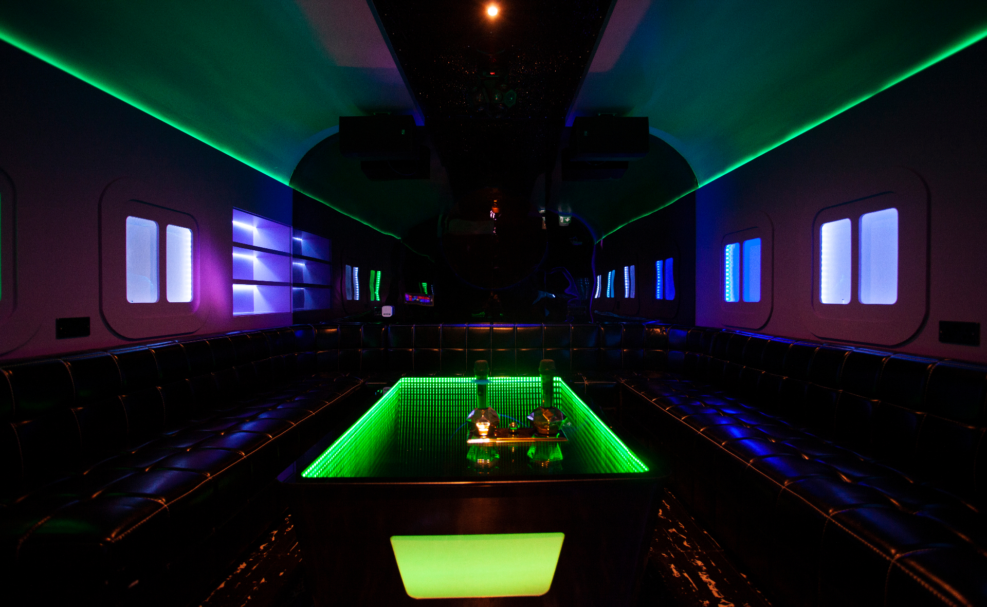 Private karaoke room K5 with purple disco velvet seating and mirror ball lighting